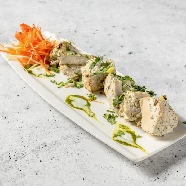 Nirvana Indian Kitchen's Malai Tikka, chicken pieces marinated in cream and spices, garnished with cilantro.