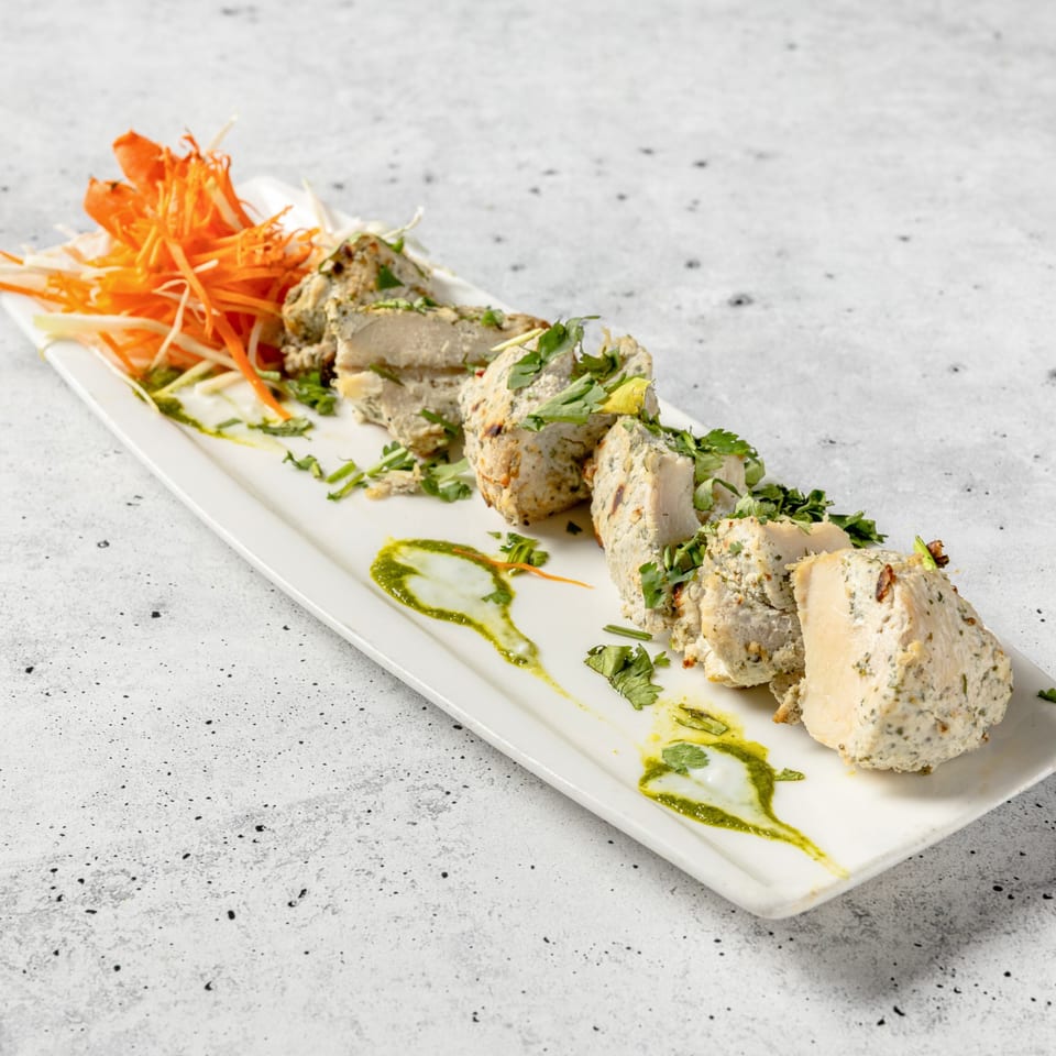 Nirvana Indian Kitchen's Malai Tikka, chicken pieces marinated in cream and spices, garnished with cilantro.
